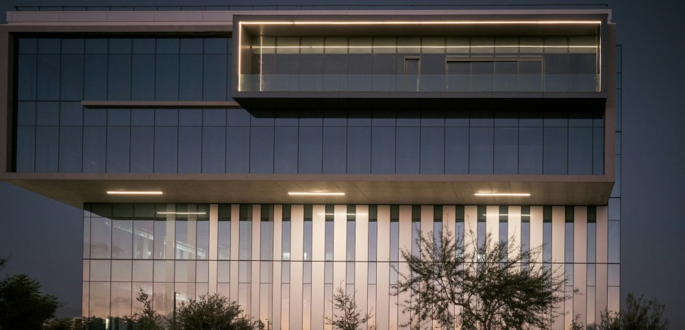 Arquitectura e infraestructura empresarial al anochecer; fotografía de referencia, no oficinas de Grupo Alvarion.